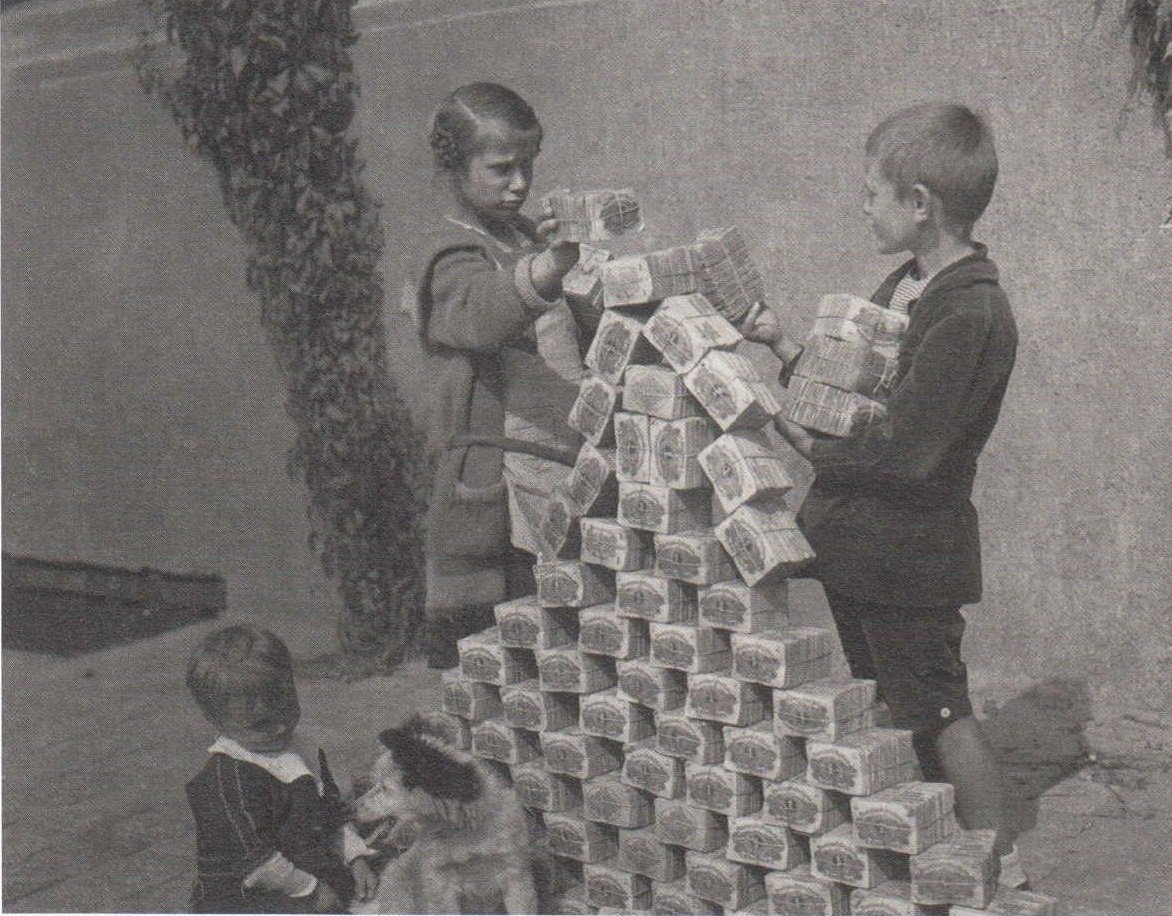 Niños jugando con una montaña de billetes